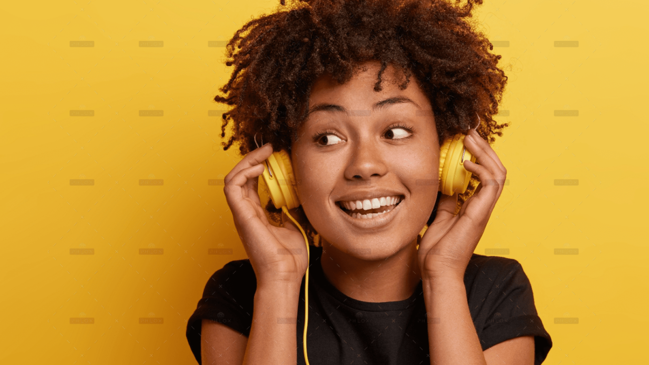 demo-attachment-36-happy-dark-skinned-woman-wears-wired-headphones-enjoys-nice-music-looks-away-has-toothy-smile